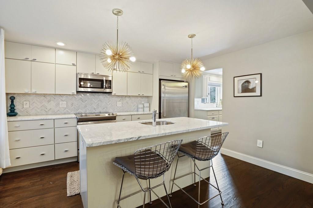 15 Herbert Road Worcester, MA 01602 - Photo 15 of 42 a kitchen with kitchen island a stove a chandelier a dining table and chairs