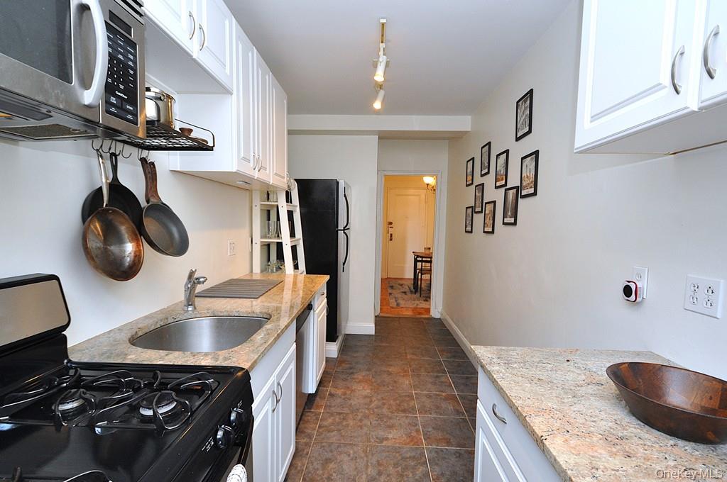 142 Garth Road, Unit 1A Scarsdale, NY 10583 - Photo 12 of 34 a kitchen with a sink a stove and cabinets