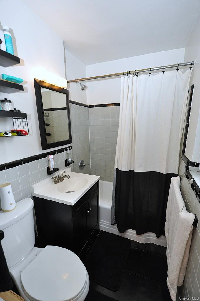 142 Garth Road, Unit 1A Scarsdale, NY 10583 - Photo 19 of 34 a bathroom with a sink a toilet a mirror and vanity