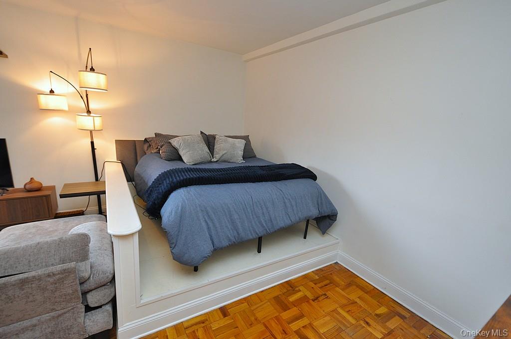 142 Garth Road, Unit 1A Scarsdale, NY 10583 - Photo 20 of 34 a bedroom with a bed and lamp