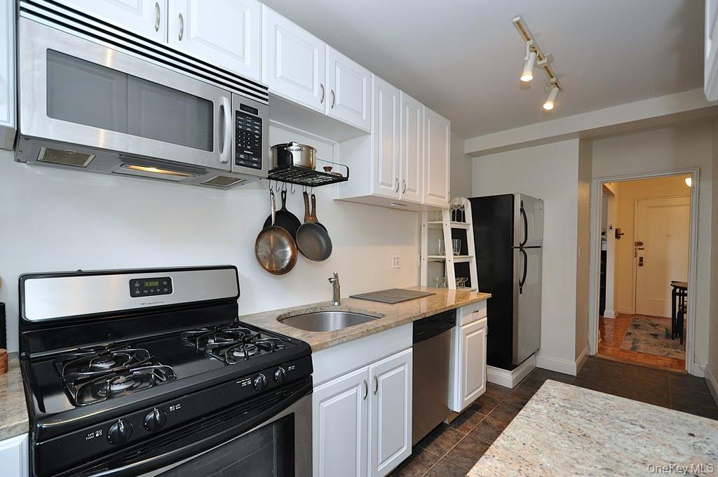 142 Garth Road, Unit 1A Scarsdale, NY 10583 - Photo 9 of 34 a kitchen with stainless steel appliances granite countertop a stove and a refrigerator