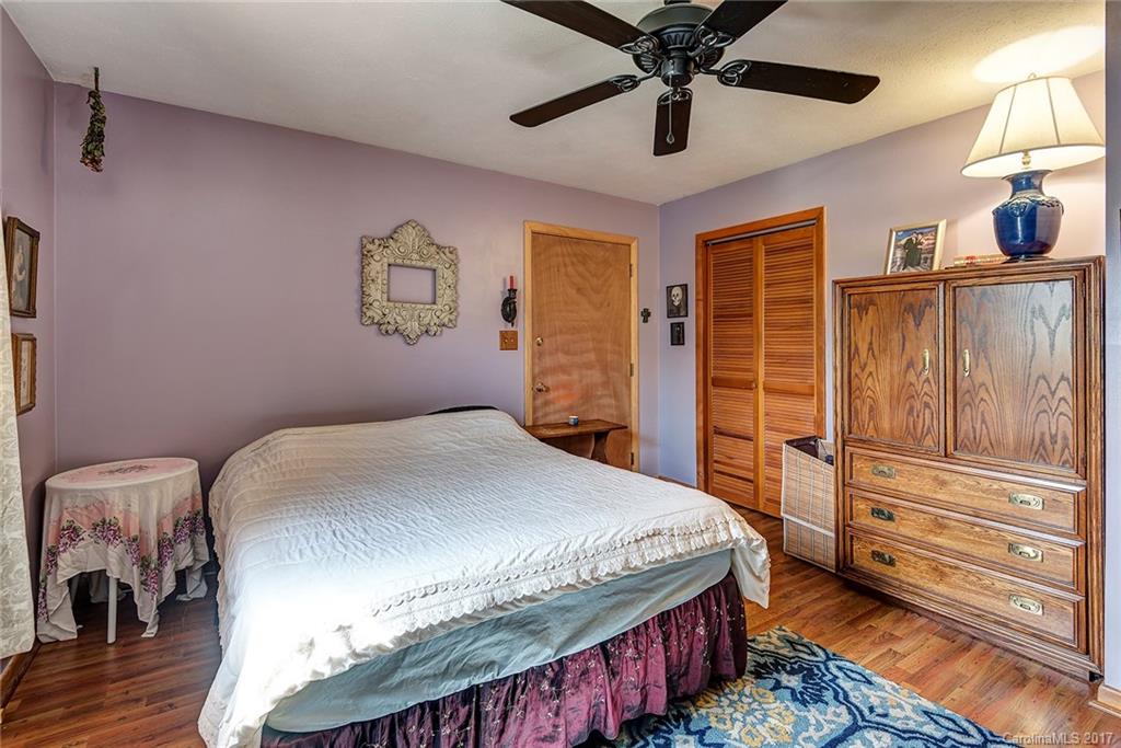 641 Newfound Road Leicester, NC 28748 - Photo 14 of 23 a bedroom with a bed and a chandelier