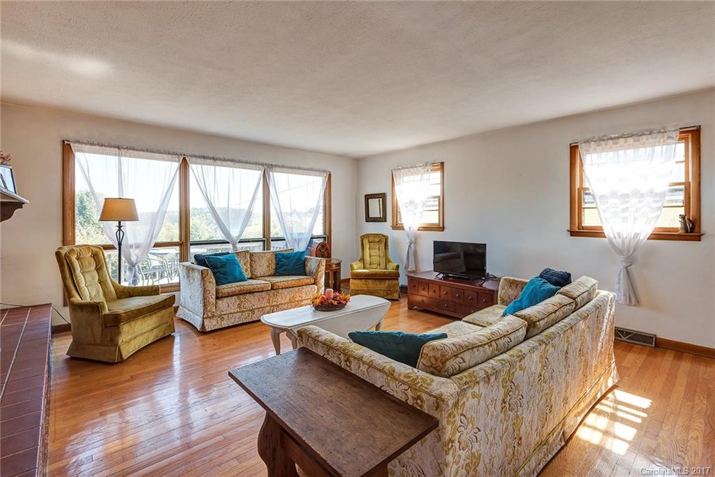 641 Newfound Road Leicester, NC 28748 - Photo 3 of 23 a living room with furniture and a flat screen tv with wooden floor