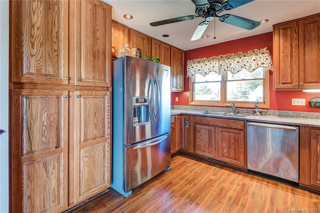 641 Newfound Road Leicester, NC 28748 - Photo 10 of 23 a kitchen with stainless steel appliances granite countertop a refrigerator a sink dishwasher and wooden cabinets with a large window