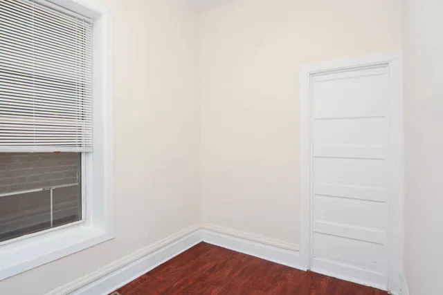 a view of a small space with wooden floor and a window