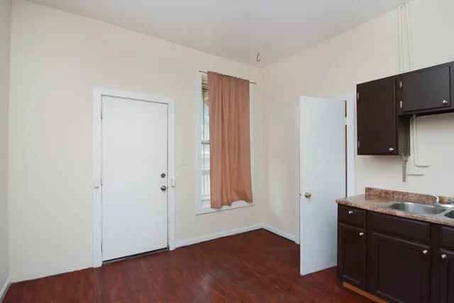 a view of a kitchen with wooden floor and a sink