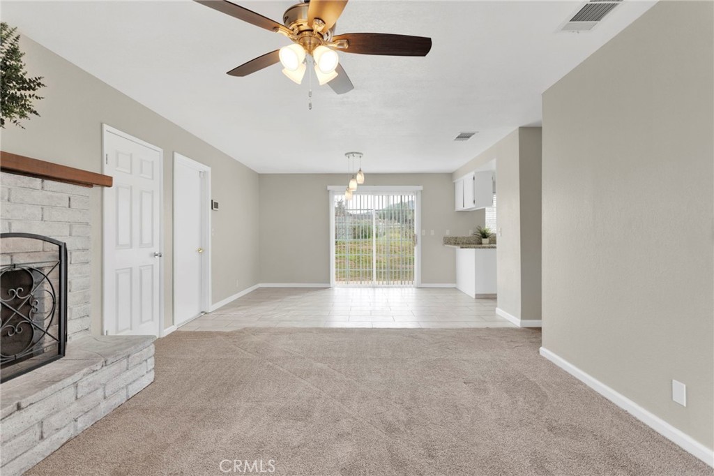 4875 Sunnyslope Road Phelan, CA 92371 - Photo 11 of 57 a view of an empty room with a fireplace and a window