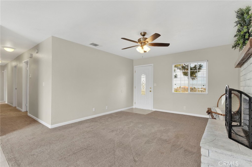 4875 Sunnyslope Road Phelan, CA 92371 - Photo 13 of 57 a view of a big room with carpet and a chandelier fan