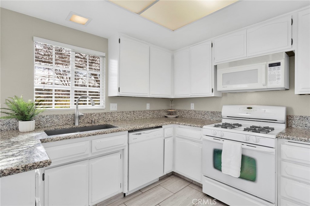 4875 Sunnyslope Road Phelan, CA 92371 - Photo 14 of 57 a kitchen with granite countertop a sink stove and cabinets