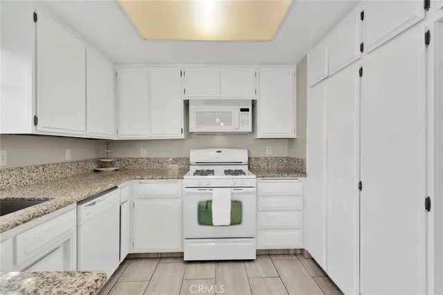a kitchen with granite countertop a sink stove and cabinets