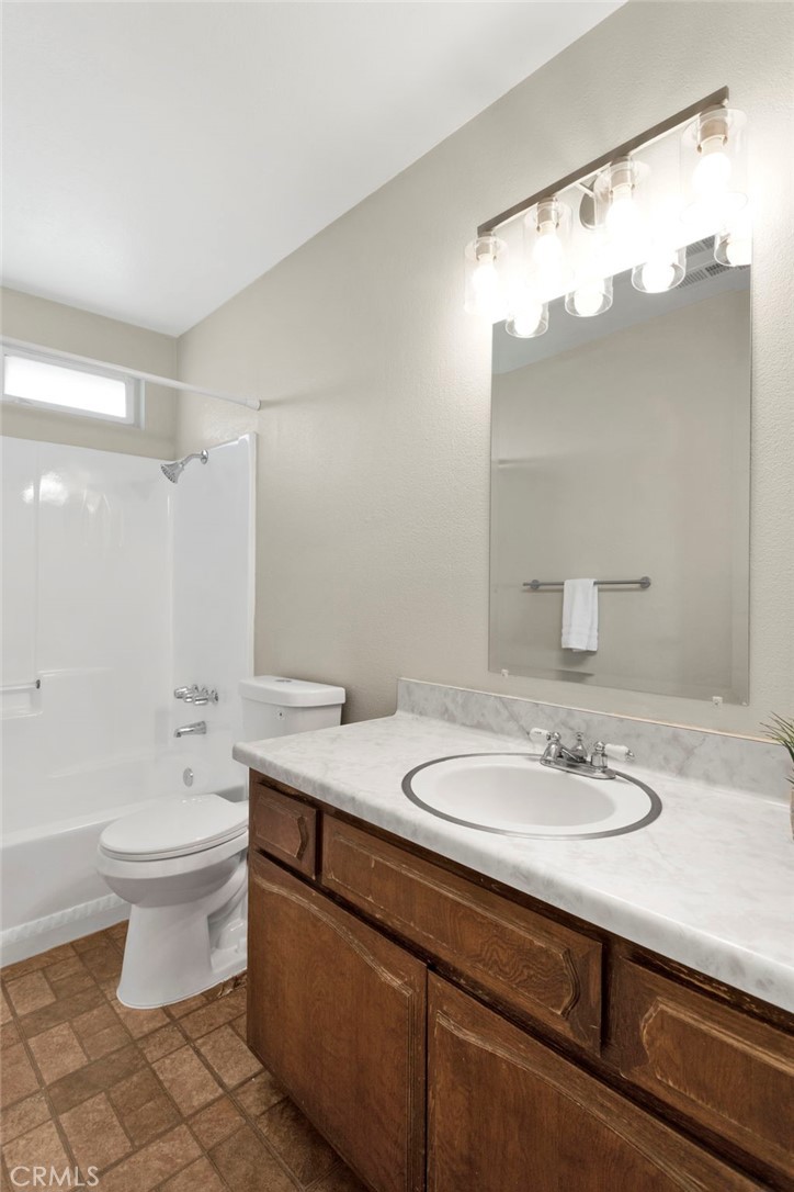 4875 Sunnyslope Road Phelan, CA 92371 - Photo 25 of 57 a bathroom with a sink a toilet and a large mirror