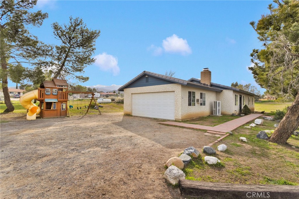 4875 Sunnyslope Road Phelan, CA 92371 - Photo 38 of 57 a front view of a house with a yard and garage