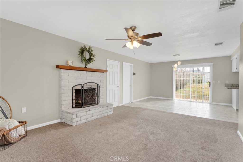 4875 Sunnyslope Road Phelan, CA 92371 - Photo 10 of 57 a view of an empty room with a fireplace and a window