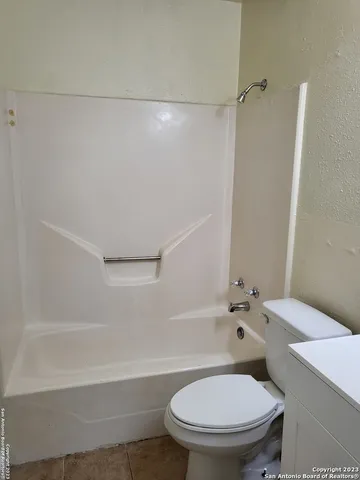 a white toilet sitting next to a bath tub
