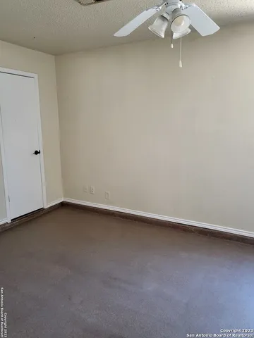 a view of a small space with a chandelier fan