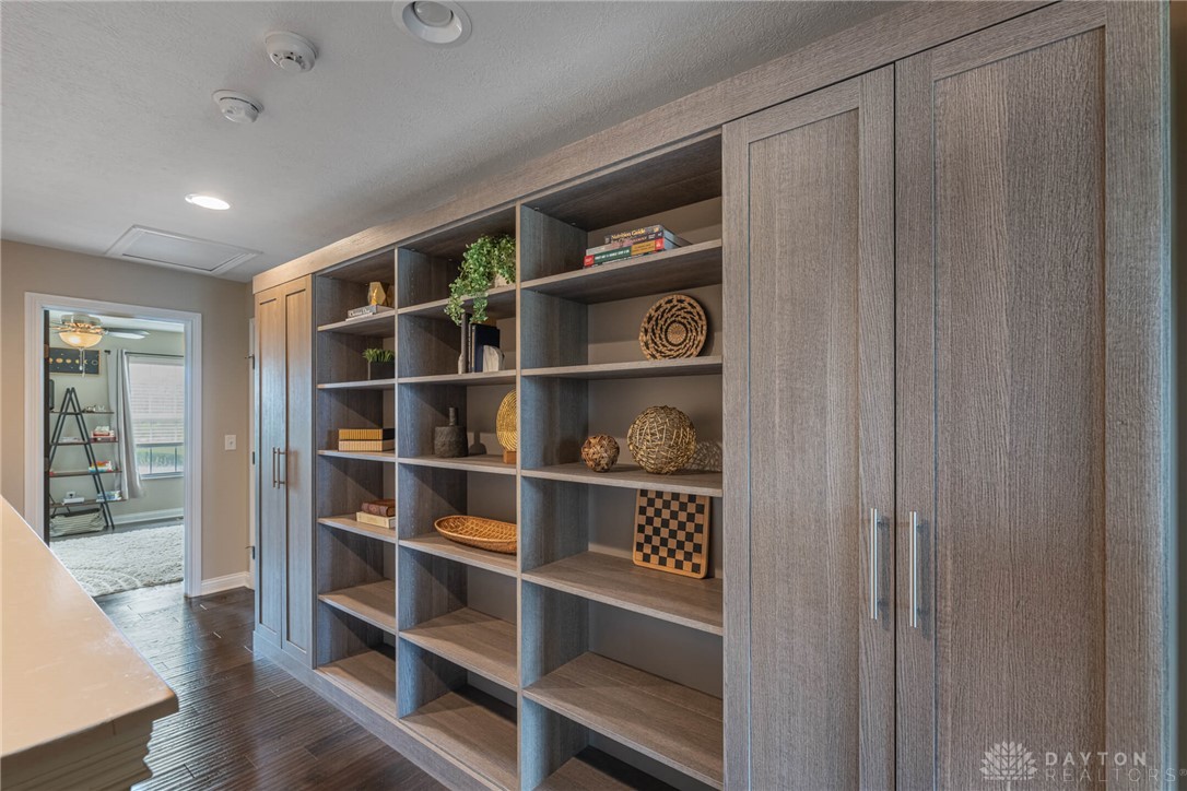 407 Brownstone Row Springboro, OH 45066 - Photo 24 of 54 This living area features rich hardwood flooring and built-in shelving, enhancing its functional elegance.