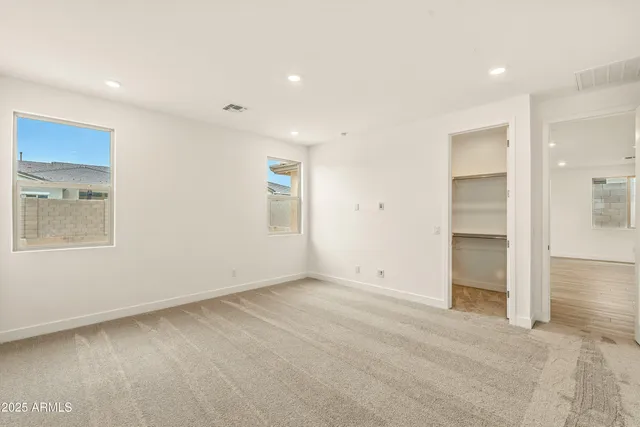 an empty room with closet and windows