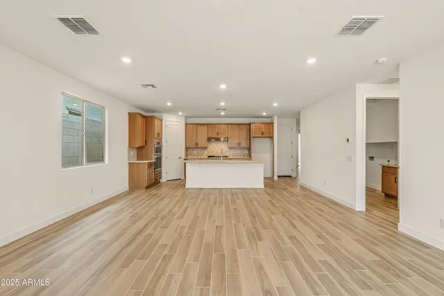 a view of a kitchen with wooden floor and windows