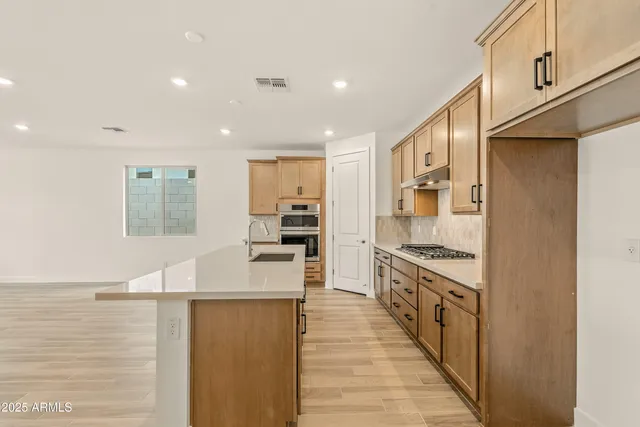 a kitchen with stainless steel appliances granite countertop a stove a sink and a refrigerator