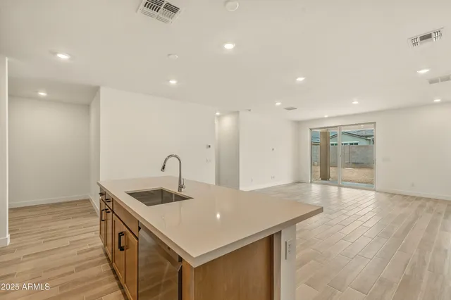 a kitchen with stainless steel appliances granite countertop a sink a stove and a wooden floors