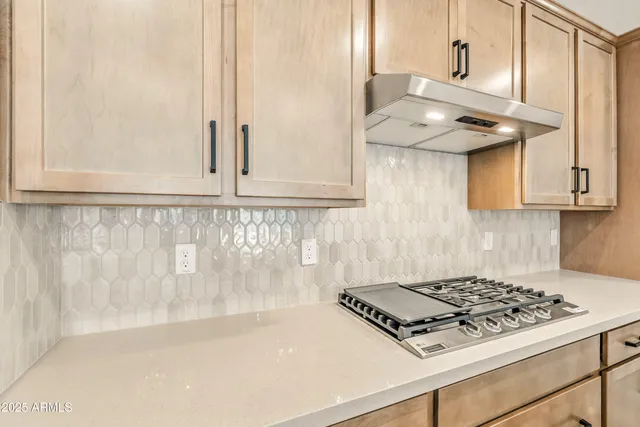 a kitchen with white cabinets and a stove