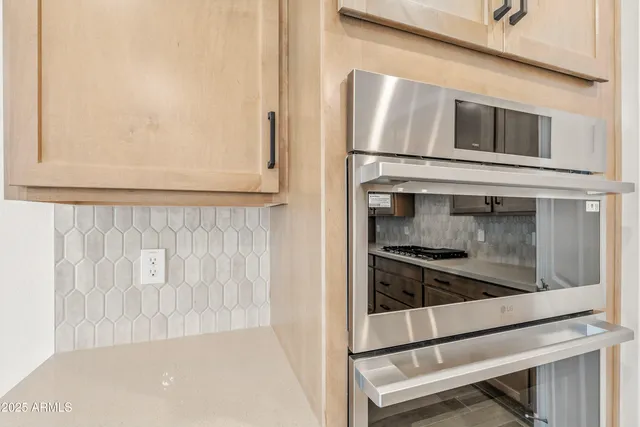 a kitchen with stainless steel appliances a stove and a white cabinets