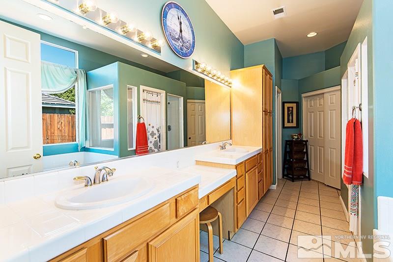 9628 Rolling Rock Way Reno, NV 89521 - Photo 15 of 23 a bathroom with a granite countertop sink and a large mirror