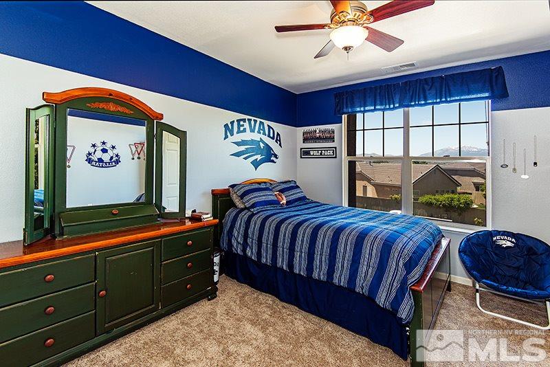 9628 Rolling Rock Way Reno, NV 89521 - Photo 17 of 23 a bedroom with a bed and dresser with mirror