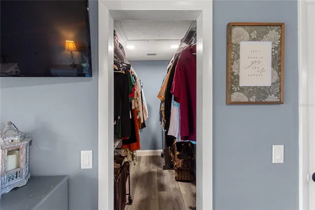 a view of walk in closet with clothes and shoes