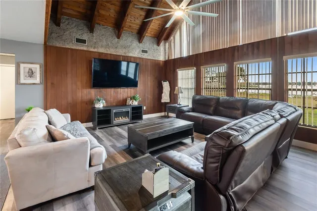a living room with furniture a flat screen tv and a large window