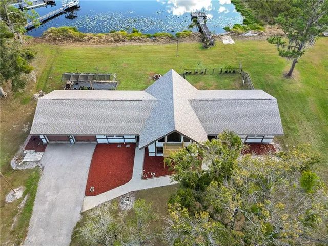 an aerial view of a house with a garden and lake view