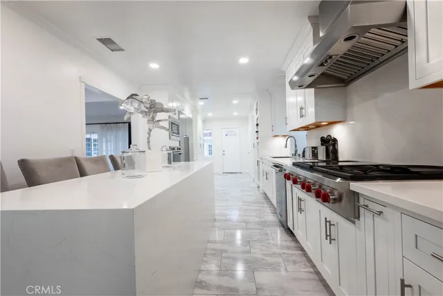 a kitchen with white cabinets and sink
