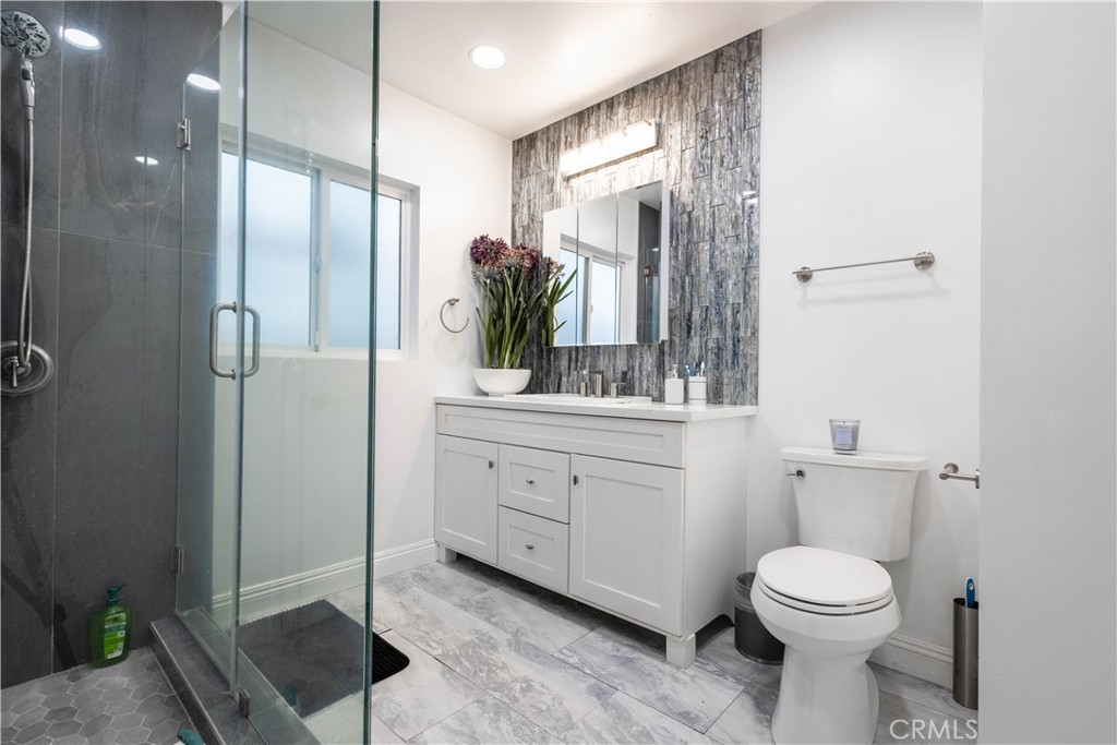 7847 Brookmill Road Downey, CA 90241 - Photo 39 of 71 a bathroom with a toilet a sink and glass door