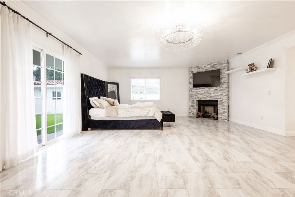 7847 Brookmill Road Downey, CA 90241 - Photo 53 of 71 a spacious bedroom with a bed a fireplace and a flat tv screen