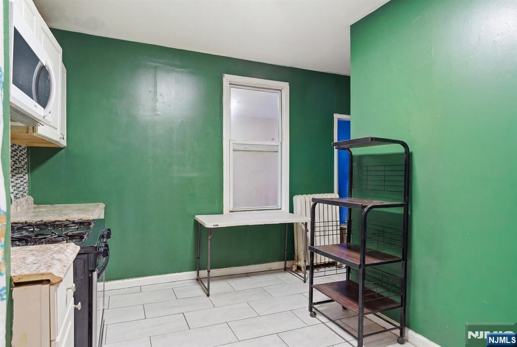 29 6th Avenue Newark, NJ 07104 - Photo 6 of 21 a living room with a chair and a fireplace