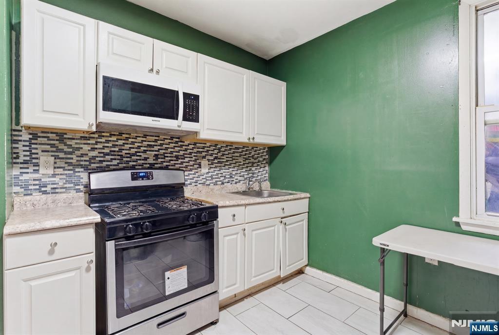 29 6th Avenue Newark, NJ 07104 - Photo 7 of 21 a kitchen with a stove and a microwave