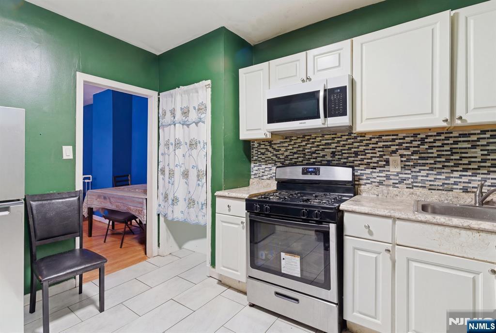 29 6th Avenue Newark, NJ 07104 - Photo 8 of 21 a kitchen with stainless steel appliances granite countertop a stove a microwave and a refrigerator