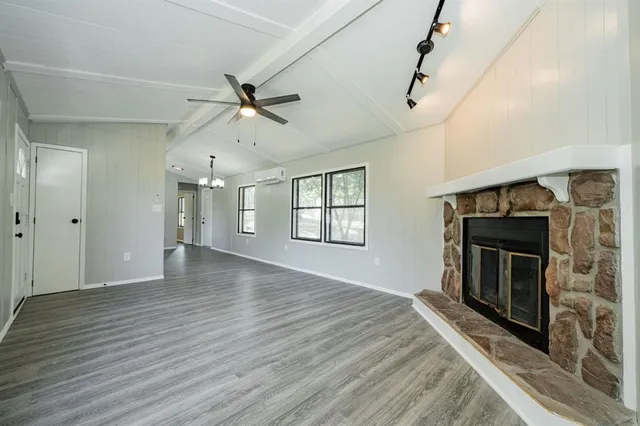 a view of an empty room with a fireplace and a window