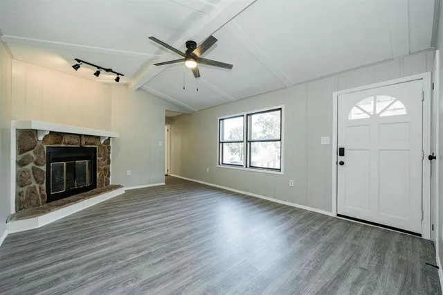 wooden floor fireplace and windows in an empty room