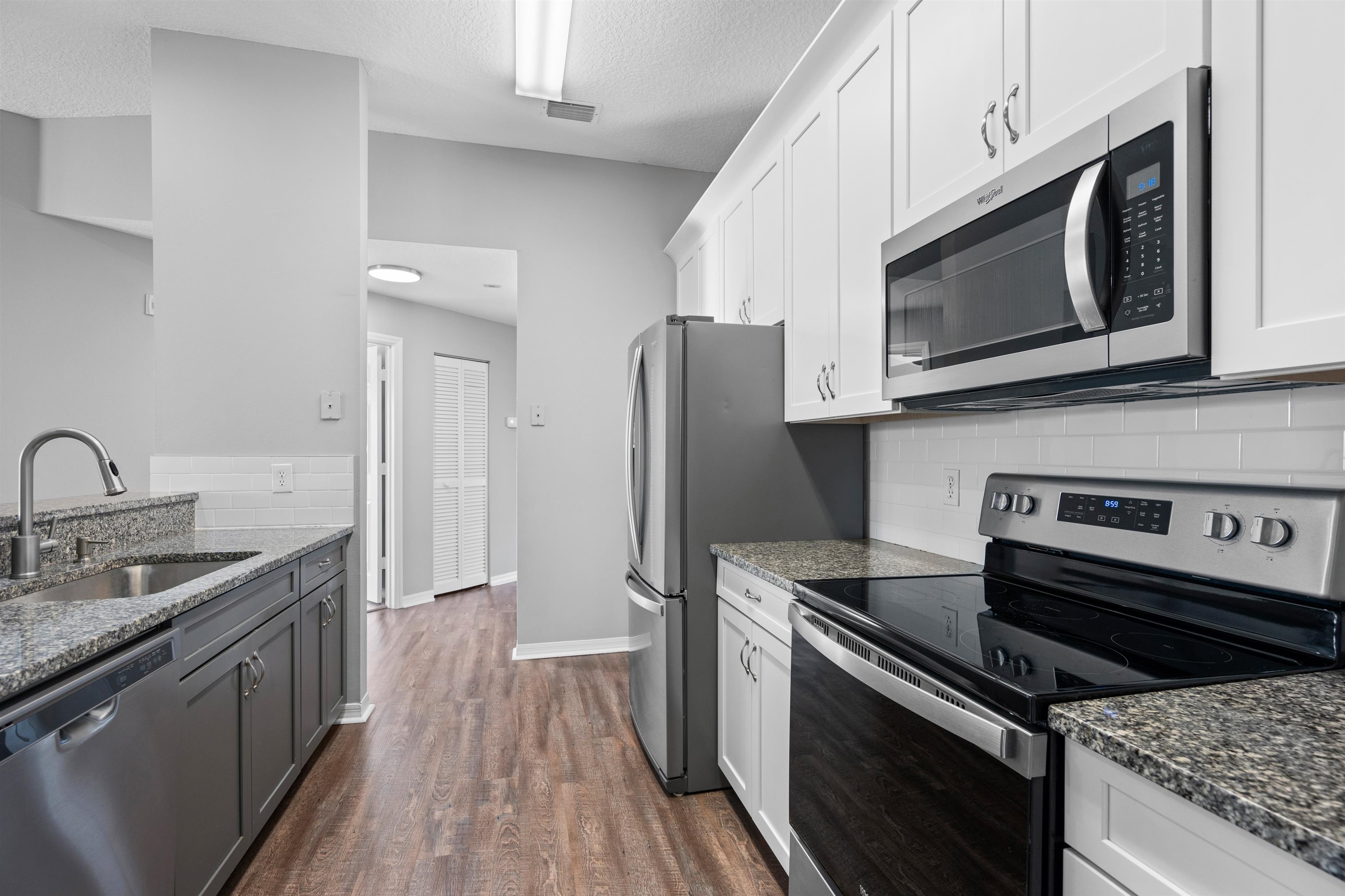 11207 Harbour Vista Circle, Unit 11207 St. Augustine, FL 32080 - Photo 14 of 42 a kitchen with stainless steel appliances granite countertop a stove microwave sink and refrigerator