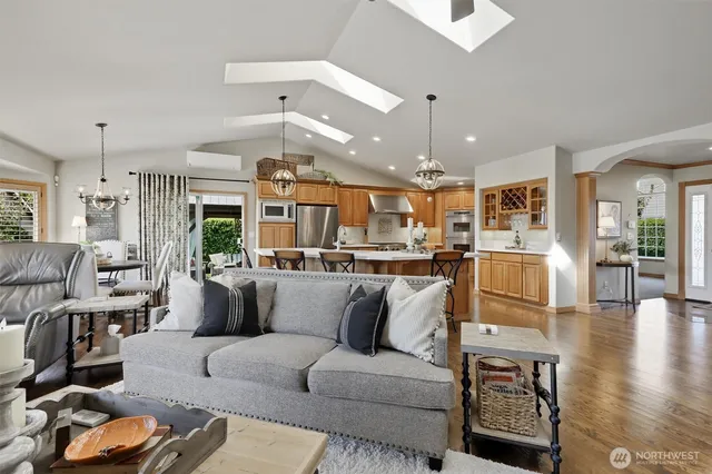a living room with furniture kitchen and a wooden floor