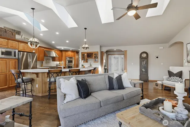 a living room with furniture kitchen view and a chandelier