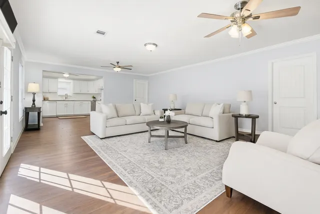 a living room with furniture and kitchen view
