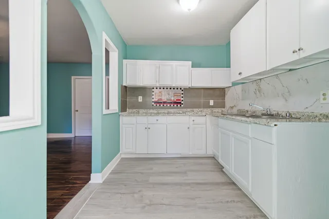 a kitchen with granite countertop a sink stainless steel appliances and cabinets