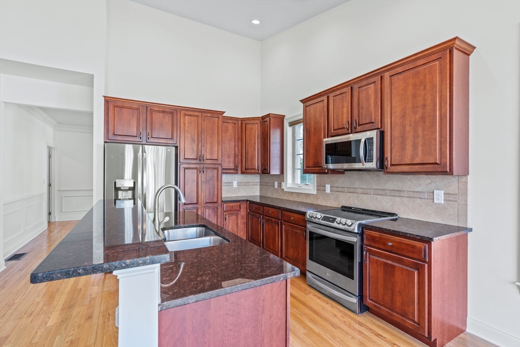 11 Pondside Lane, Unit 11 Bolton, MA 01740 - Photo 15 of 29 a kitchen with stainless steel appliances granite countertop a stove a sink dishwasher and a microwave oven with cabinets