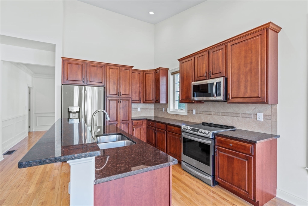11 Pondside Lane, Unit 11 Bolton, MA 01740 - Photo 17 of 32 a kitchen with stainless steel appliances granite countertop a stove a sink dishwasher and a microwave oven with cabinets