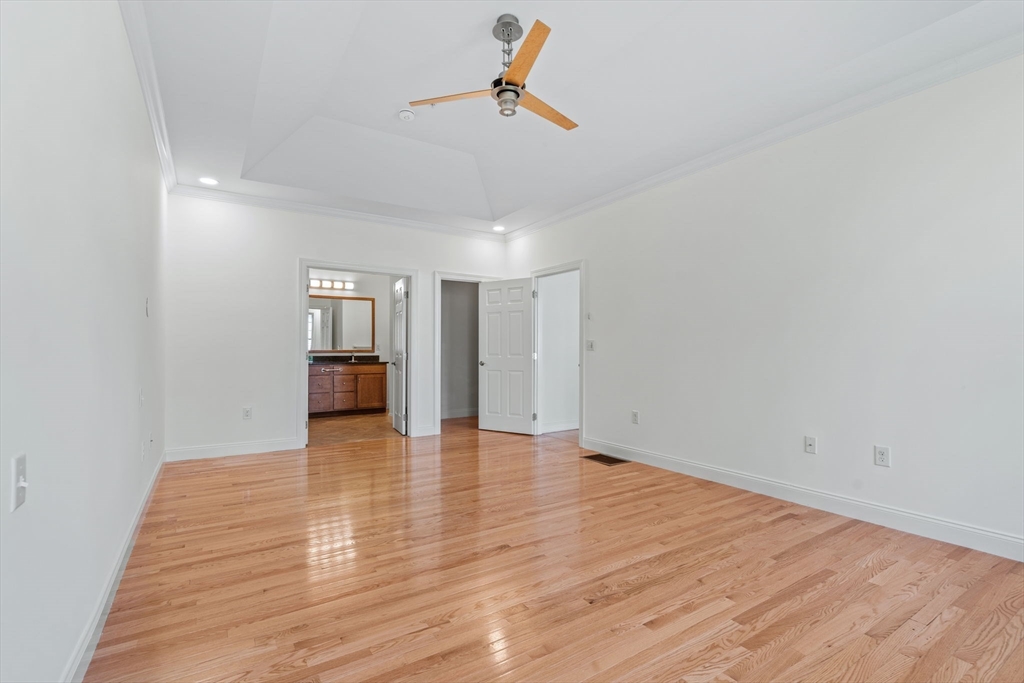 11 Pondside Lane, Unit 11 Bolton, MA 01740 - Photo 20 of 29 a view of empty room with wooden floor and ceiling fan