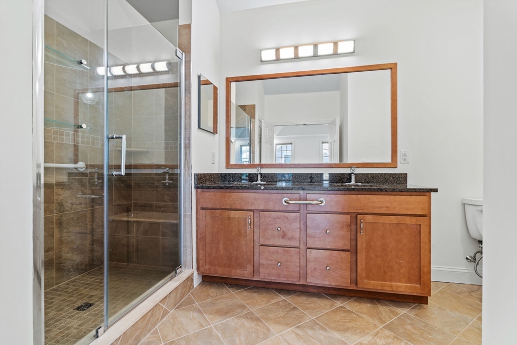 11 Pondside Lane, Unit 11 Bolton, MA 01740 - Photo 24 of 32 a bathroom with a granite countertop sink a mirror and shower