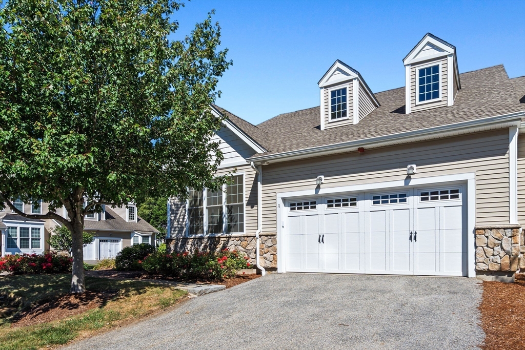 11 Pondside Lane, Unit 11 Bolton, MA 01740 - Photo 6 of 29 a front view of a house with a yard and garage