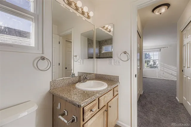 a bathroom with a granite countertop sink and a mirror